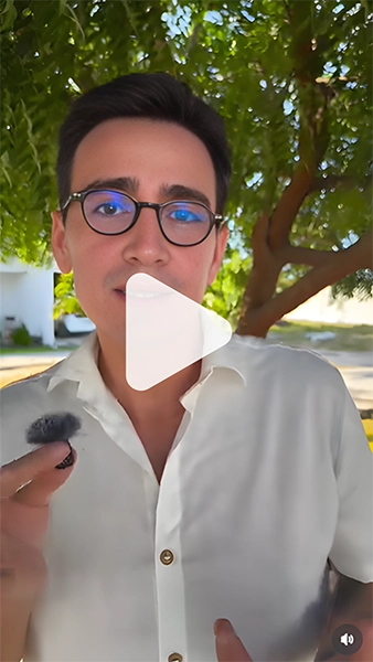 imagem do Pablo falando em um microfone de lapela, em sua mão, de camisa branca, em um ambiente externo